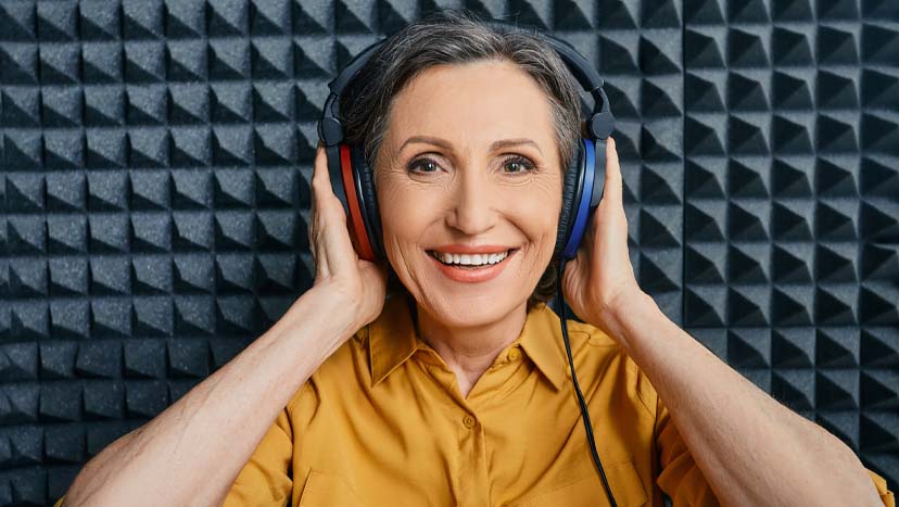 Lady in a soundbooth geeting a hearing test